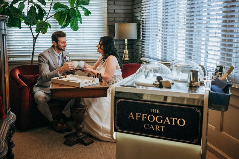A couple share cappuccinos from the cart at their wedding